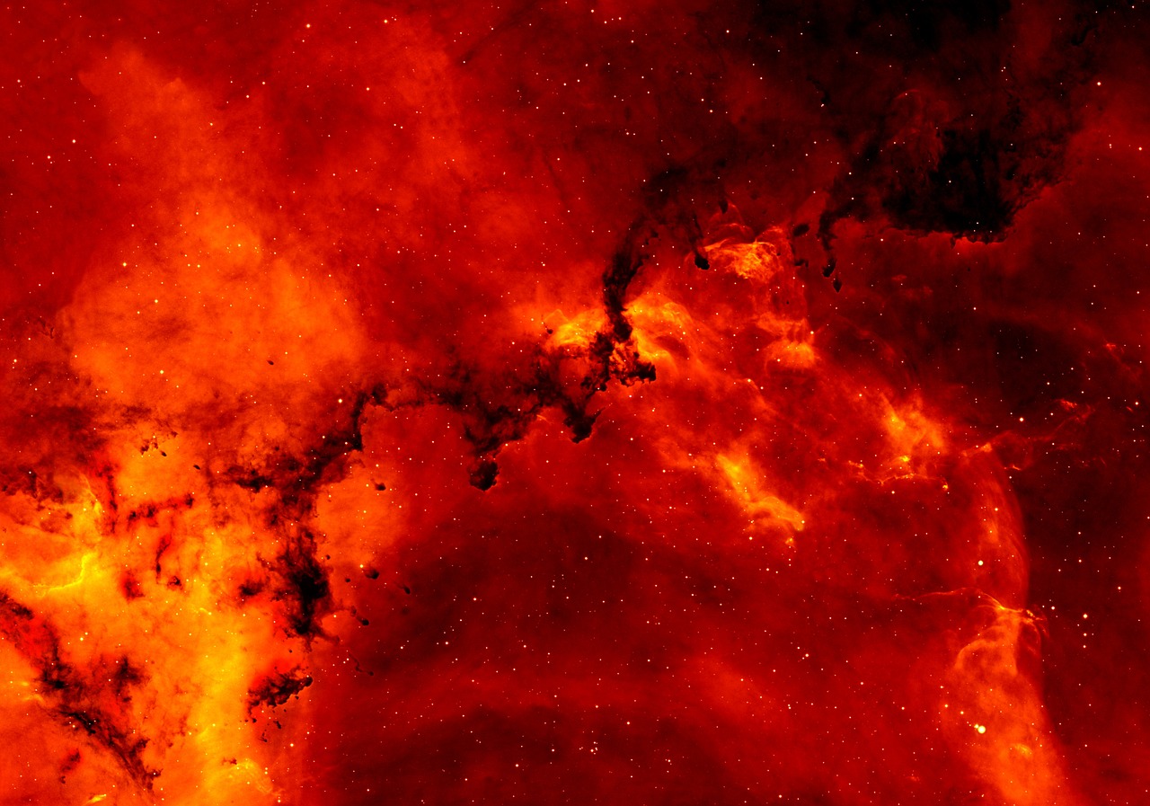 A vivid red emission nebula filled with stars